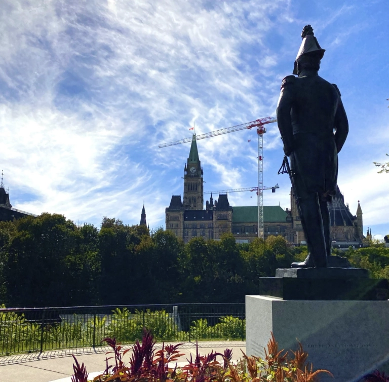 soldier statue looks over parliament buildings in ottawa